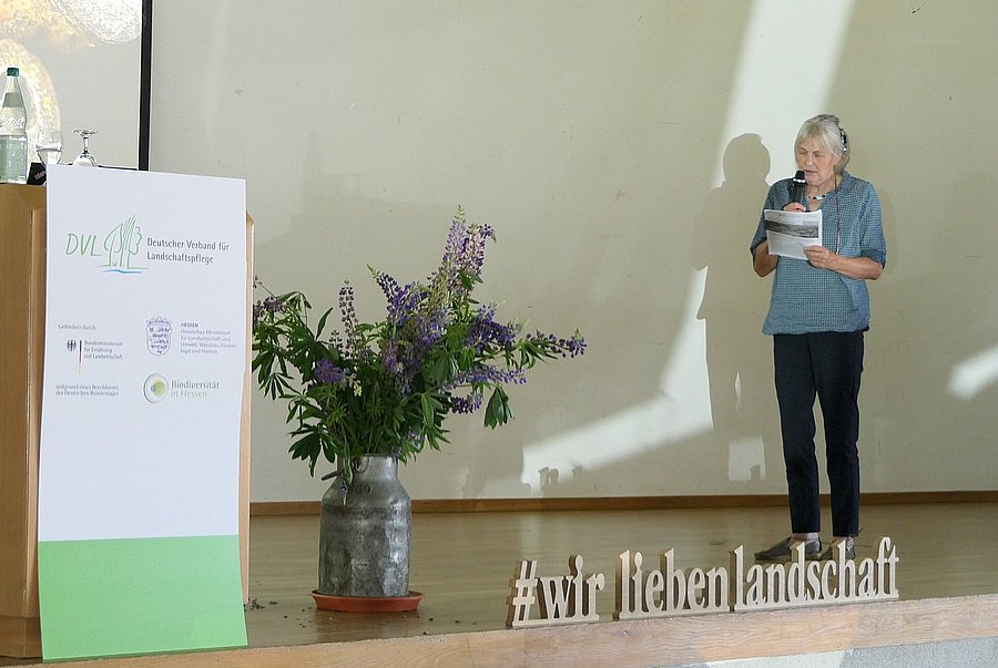 Angela Odenhardt vom NABU Edertal stellt ihre Idee der Herstellung von Pflanzenkohle aus kommunalem Wegraingras vor. ©DVL