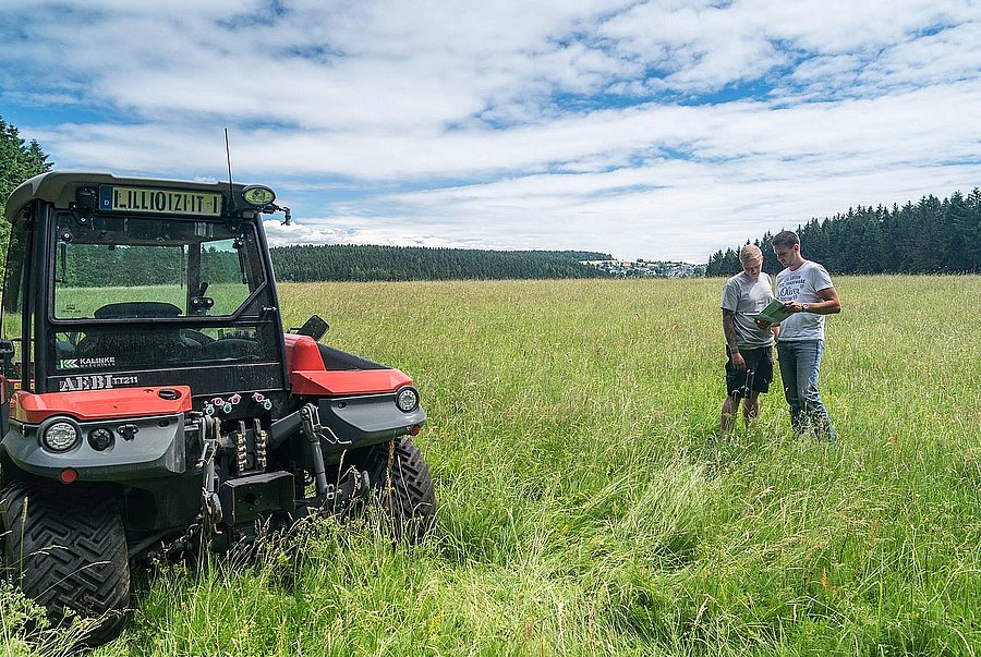 2 Männer beraten sich auf dem Feld