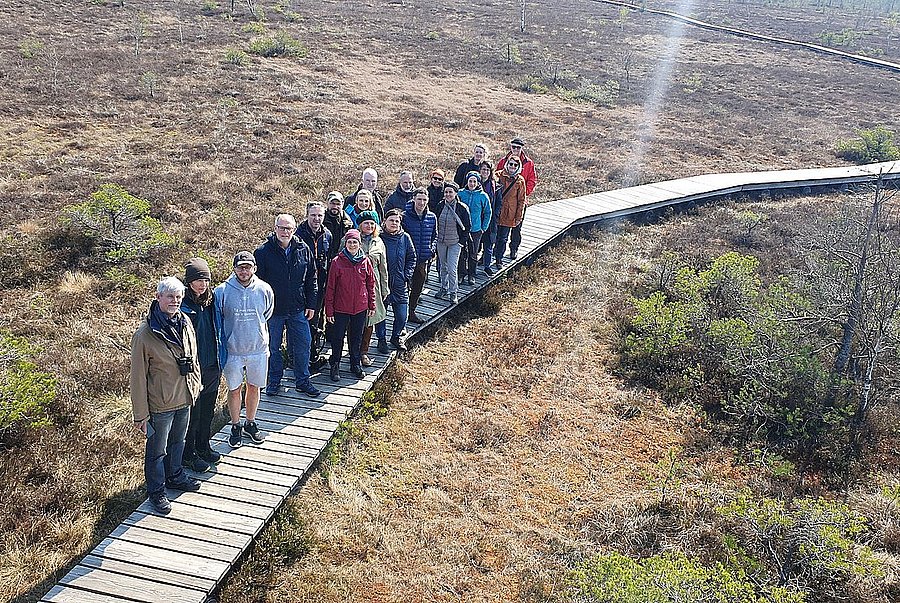 Gruppe von Menschen auf einem Steg im Moor aus der Vogelperspektive
