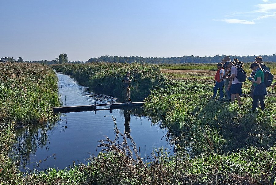 Ein Mann steht auf einer Schleuse in einem Graben