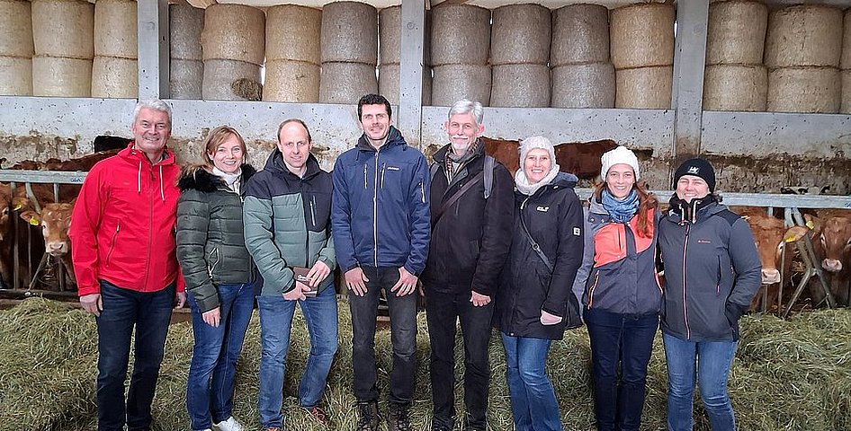 Eine Gruppe von Menschen in einem Kuhstall