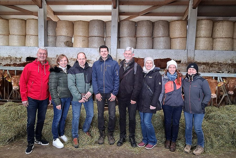 Eine Gruppe von Menschen in einem Kuhstall