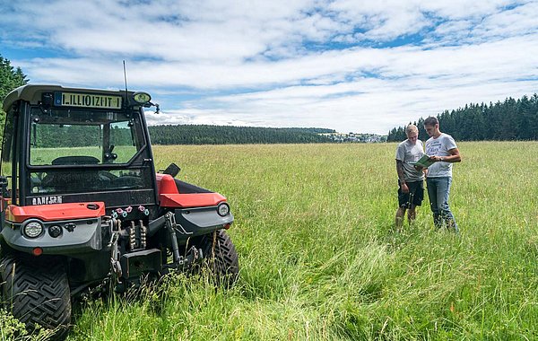 GAP ab 2028 ©S. Weigelt Zwei Personen neben einem Traktor auf einer landwirtschaftlich genutzten Fläche.