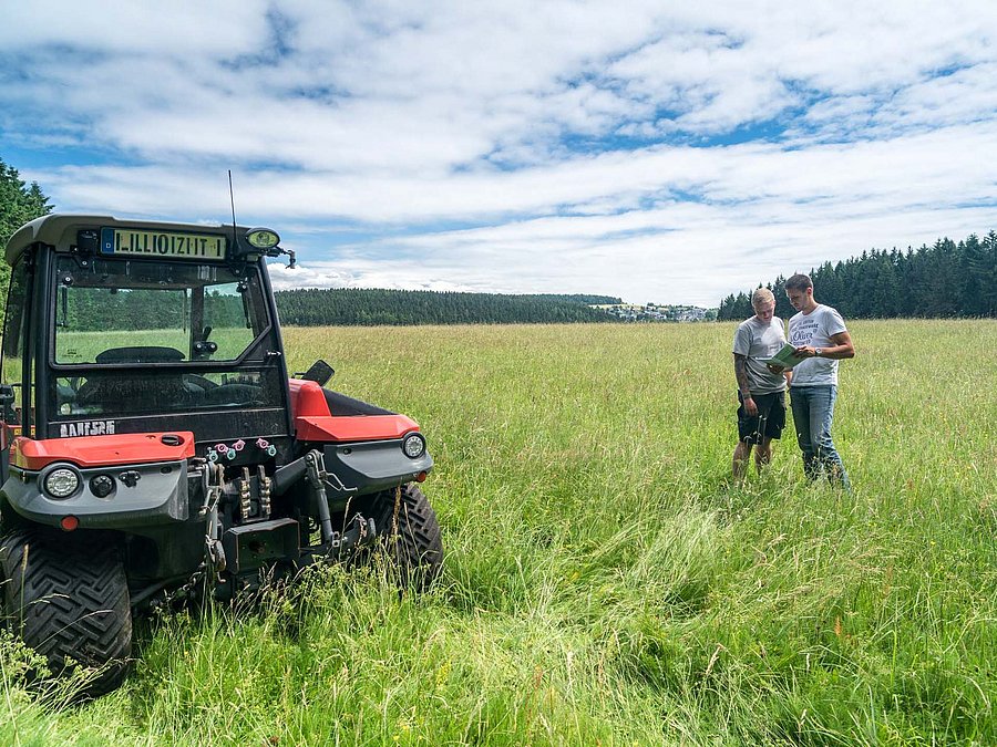 GAP ab 2028 ©S. Weigelt Zwei Personen neben einem Traktor auf einer landwirtschaftlich genutzten Fläche.